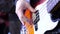 A man is playing guitar on stage. Young man playing on electric guitar close-up. Artist Guitarist hand play electricity