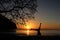 Man playing somersaults on the beach at sunset, red sky