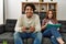 Man playing video game while unhappy girlfriend read book at home