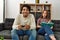Man playing video game while unhappy girlfriend read book at home