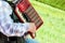 The man plays an accordion on a green lawn