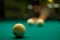 A man plays billiards and prepares to hit. A man aims his cue at a billiard ball while leaning towards the table. In the