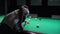 A man plays Russian billiards. Rolls a billiard ball into the pocket