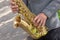 Man plays on saxophone in the park. Street musician with sax performs music for charity. Public solo performance by wind