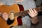 Man plays a six-stringed wooden guitar, musical concept, close-up