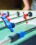 Man plays table football. Detail of man`s hands playing the kicker