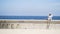 Man plays trumpet on background of sea. Action. Swarthy man plays trumpet sitting on embankment by beautiful sea