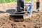 Man plows the ground with an electric cultivator