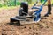 Man plows the ground with an electric cultivator