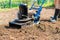 A man plows the ground in the garden with an electric cultivator