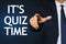 Man pointing at phrase IT`S QUIZ TIME on dark blue background, closeup view