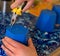 A man pokes a hole in a flower pot with a hot nail and pliers