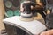 A man polishes the optics of a car\'s headlights with a polishing machine at a service station.