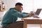 Man with poor posture using laptop at table indoors