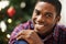 Man, portrait and smile in home on christmas for celebration, holiday and festive spirit in living room. African person