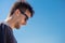 Man portrait with sunglasses bowed his head on sky background