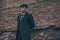 A man posing in the image of an English retro gangster near brick wall