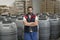 Man posing in workplace looking at camera, barrels in background