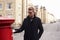 Man Posting Letter In Red British Postbox