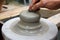 Man potter hands working on pottery clay wheel