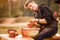 Man potter work with clay ware. Young man potter on his workshop with nature background