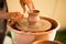 Man potter work with clay ware. Young man potter on his workshop with nature background