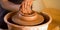 Man potter work with clay ware. Young man potter on his workshop with nature background