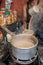 Man pour cup of hot tea Indian style or chai for customers in his shop along the street in Kolkata, India