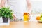 Man pouring apple juice from jug into an empty glass in the kitchen