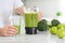 Man pouring delicious smoothie into glass at white marble table, closeup