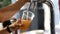 Man pouring a draft beer into a plastics glass