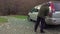 Man pouring gasoline into an empty fuel tank from a plastic red gas can