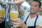 Man pouring glass lager from barrel