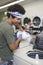 Man Pouring Liquid Solution In Washing Machine