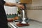 Man pouring sugar in a glass bowl that\'s on the weighing scale in the kitchen