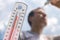 Man pouring water on his head in extreme heat, Thermometer in summer day shows or indicate high temperature