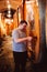 Man pouring wine from tab in underground wine cellar with rows of big oak barrels