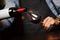 Man pouring wine into wineglass, male hand holding bottle