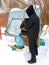 a man pours clean water into a bottle from an old bucket from a well