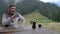 A man pours coffee from a coffee maker in the morning in the mountains