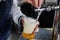 Man pours draft beer in plastic glass during picnic. Close up image with no face. Tap of movable bar counter with hands and
