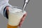 Man pours draft beer in plastic glass during picnic. Close up isolated image with no face. Tap of movable bar counter with hands
