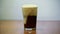 Man pours kvass, dark beer, into a glass. Foam rises and goes overboard. Poured out. slowmotion