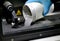 Man pours metal powder into the chamber of a laser sintering machine