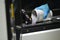 Man pours metal powder into the chamber of a laser sintering machine