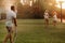 A man pours water from a hose on his wife and daughter on the lawn