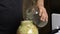 A man pours water and salt into a jar of chopped cabbage. Sauerkraut at home during a pandemic. Close-up shot
