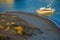 MAN ON POWER BOAT AT WATER EDGE BY BEACH IN LATE SUNSET