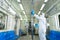Man in PPE suits with mask wiping down surface to prevent pandemic of coronavirus