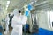 Man in PPE suits with mask wiping down surface to prevent pandemic of coronavirus